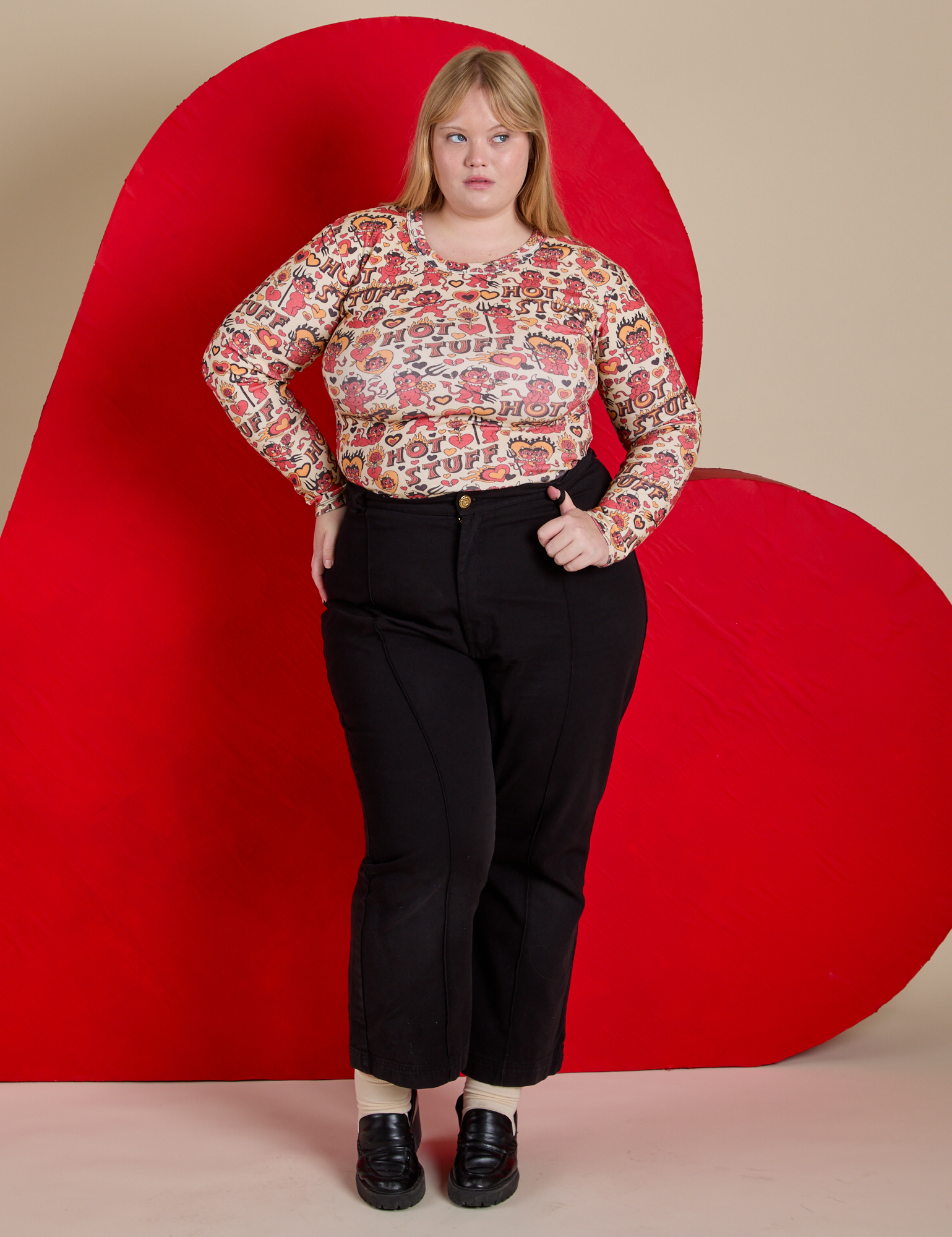 Juliet is wearing Long Sleeve Baby Tee in Hot Stuff Print tucked into black Western Pants