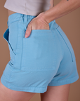 Close up of Alex's hand in the back pocket of Classic Work Shorts in Baby Blue