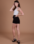 Angled back view of Classic Work Shorts in Basic Black and Cropped Tank in Vintage Tee White on Alex