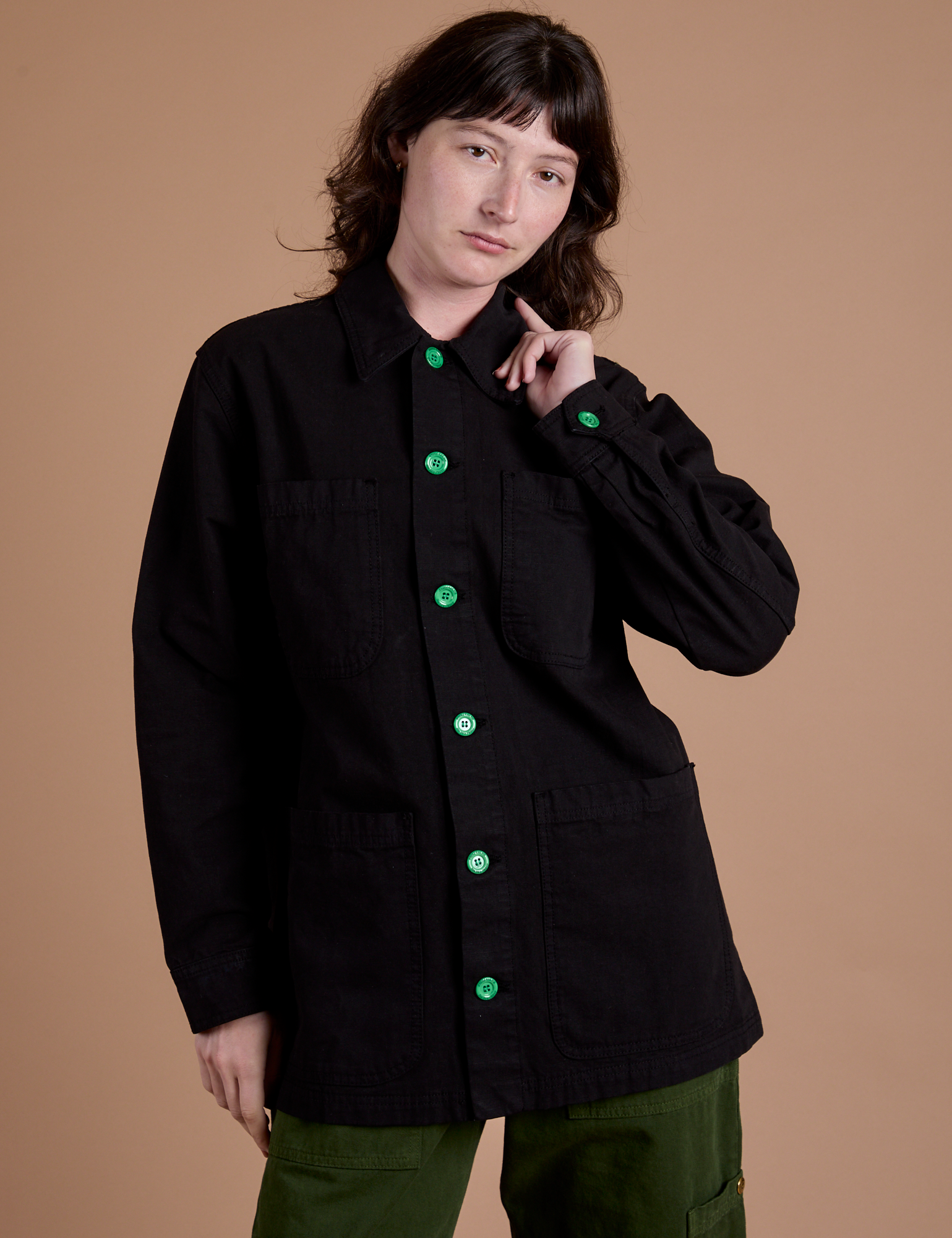 Alex is wearing a buttoned up Ripstop Field Coat in Basic Black