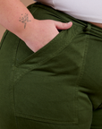 Close up of Juliet's hand in the front pocket of Organic Work Pants in Evergreen