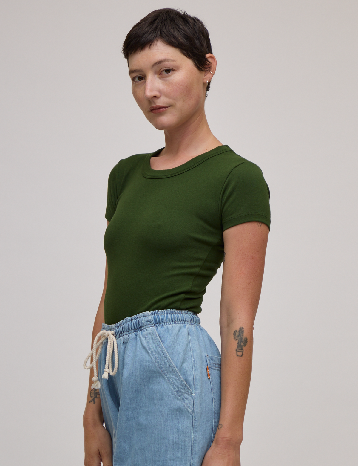 Angled front view of Baby Tee in Evergreen on Alex