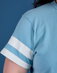 Painted Burly Tee in Baby Blue sleeve close up with two white painted stripes on Ashley