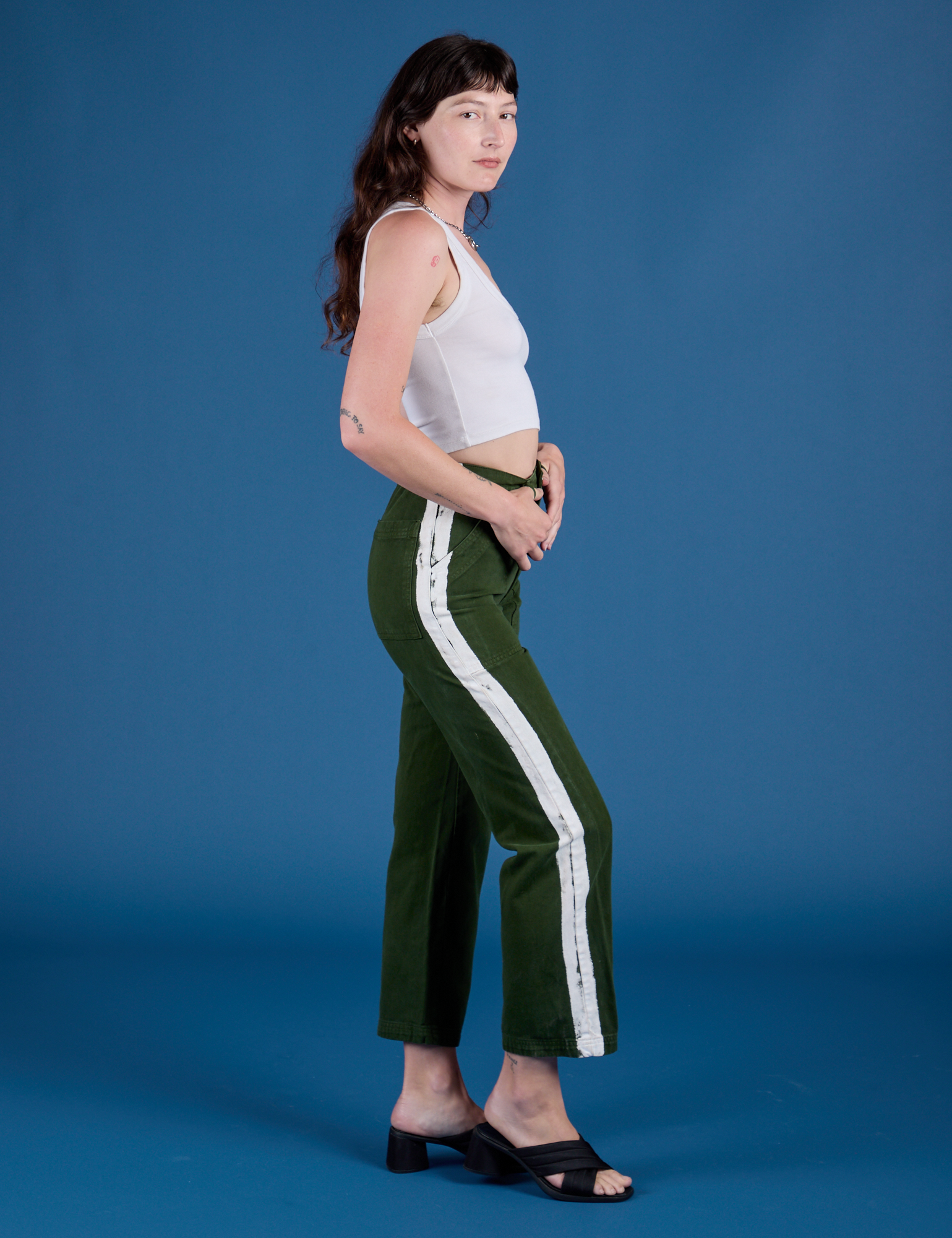 Side view of Painted Work Pants in Evergreen and vintage tee white Cropped Tank