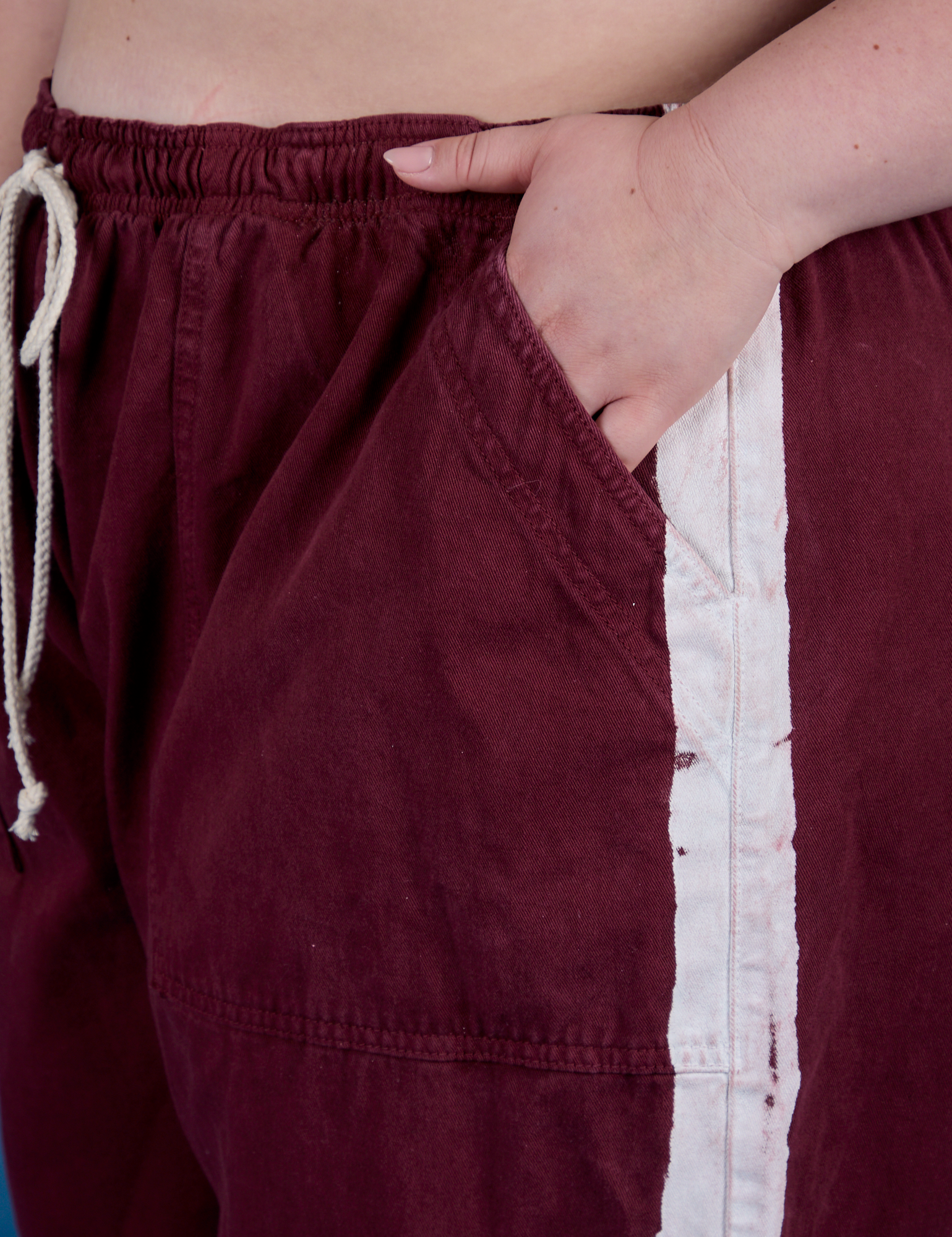 Close up of Ashley's hand in the front pocket of Painted Drop Pocket Cargo Pants in Red Wine