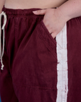 Close up of Ashley's hand in the front pocket of Painted Drop Pocket Cargo Pants in Red Wine