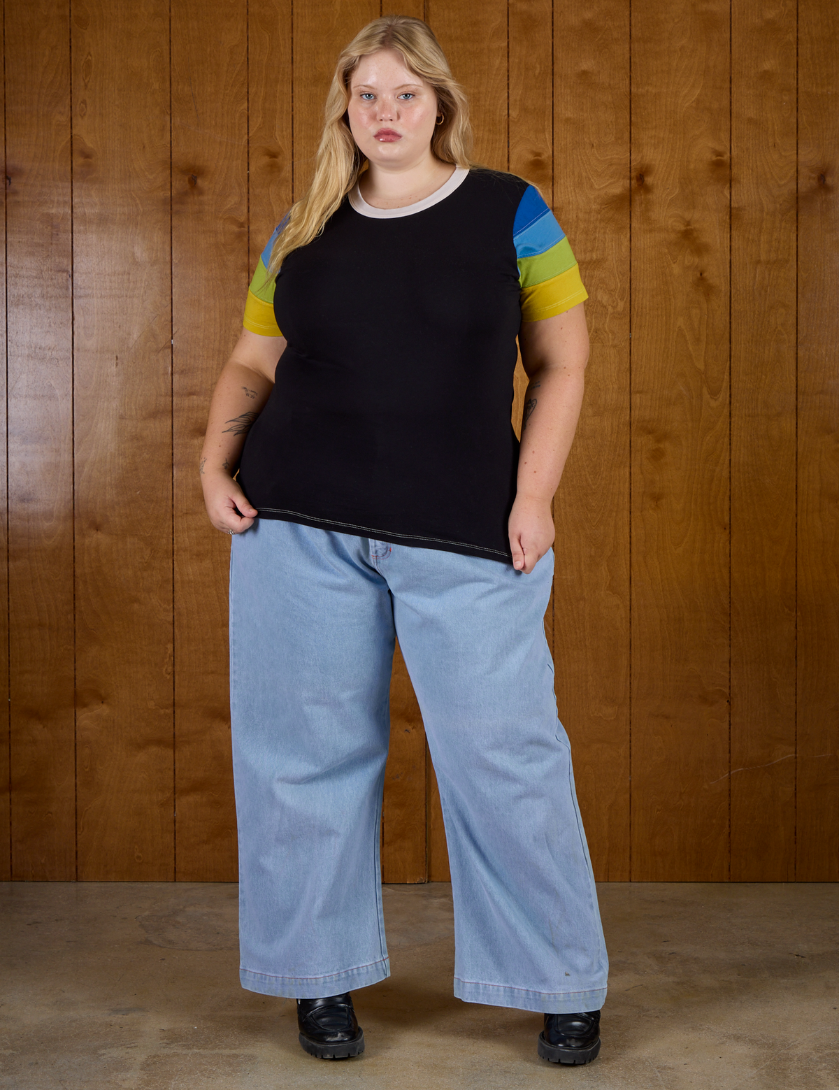 Juliet is 5'7" and wearing L Calypso Tee in Black Multi paired with light wash denim wide leg trousers