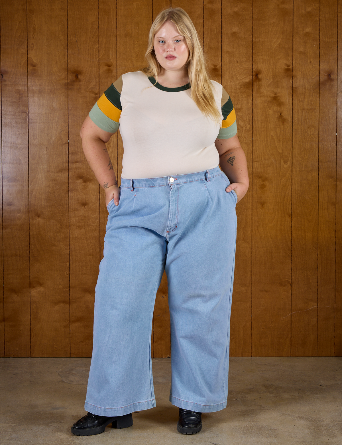 Juliet is wearing Calypso Tee in Off White Multi and light wash Denim Wide Leg Trousers