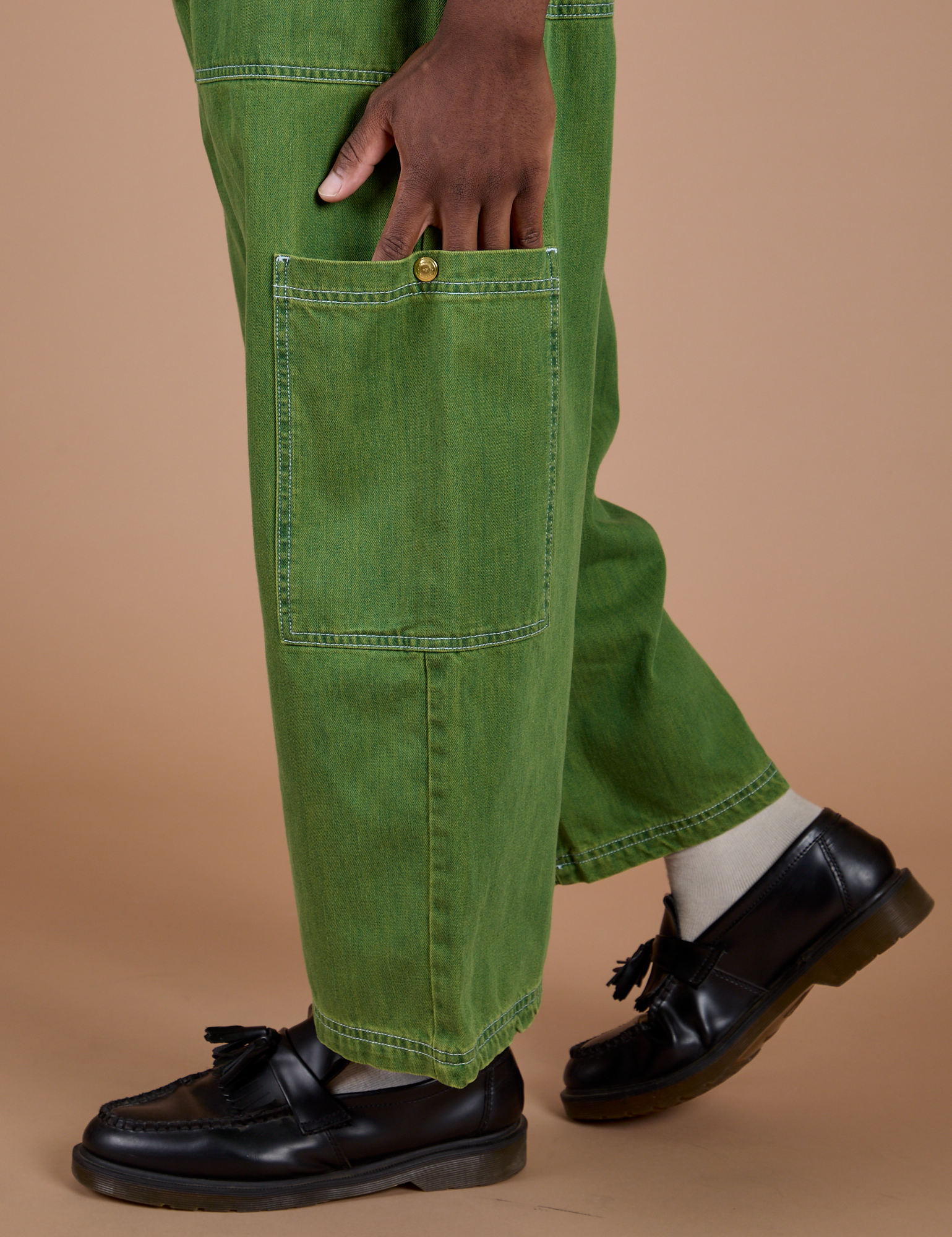 Close up of Isaac's hand on the side pant leg pocket of Denim Drop Pocket Pants in Green Overdye