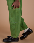 Close up of Isaac's hand on the side pant leg pocket of Denim Drop Pocket Pants in Green Overdye