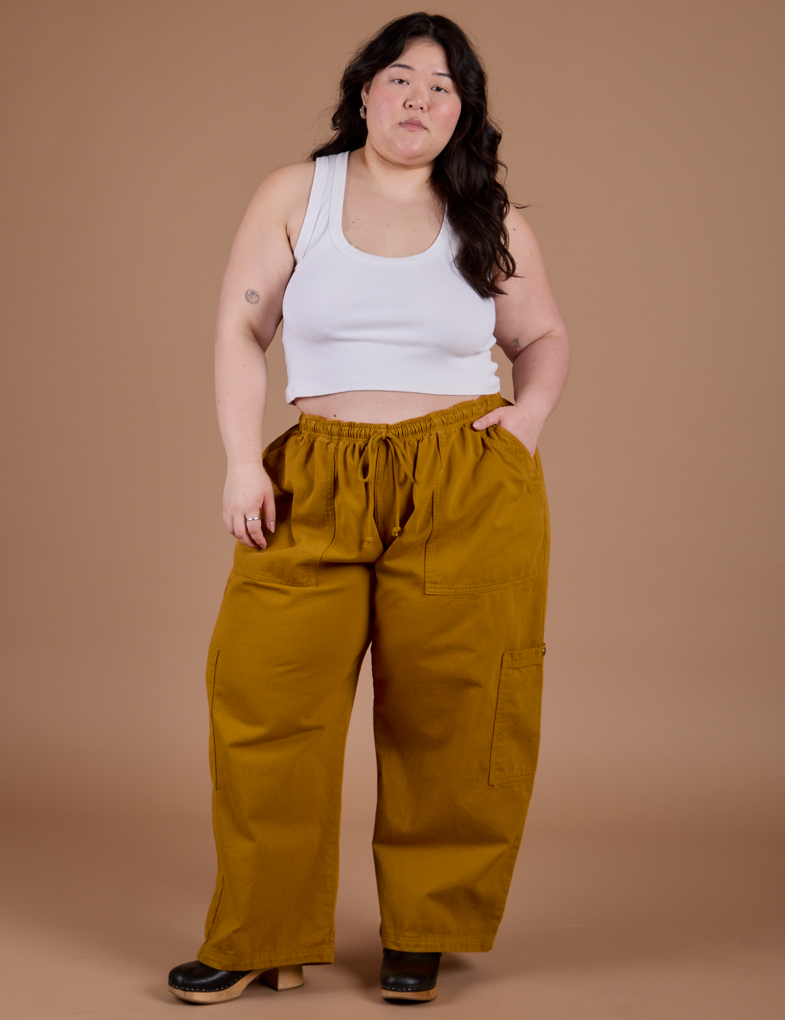 Ashley is wearing Drop Pocket Cargo Pants in Spicy Mustard and Cropped Tank in Vintage Tee White