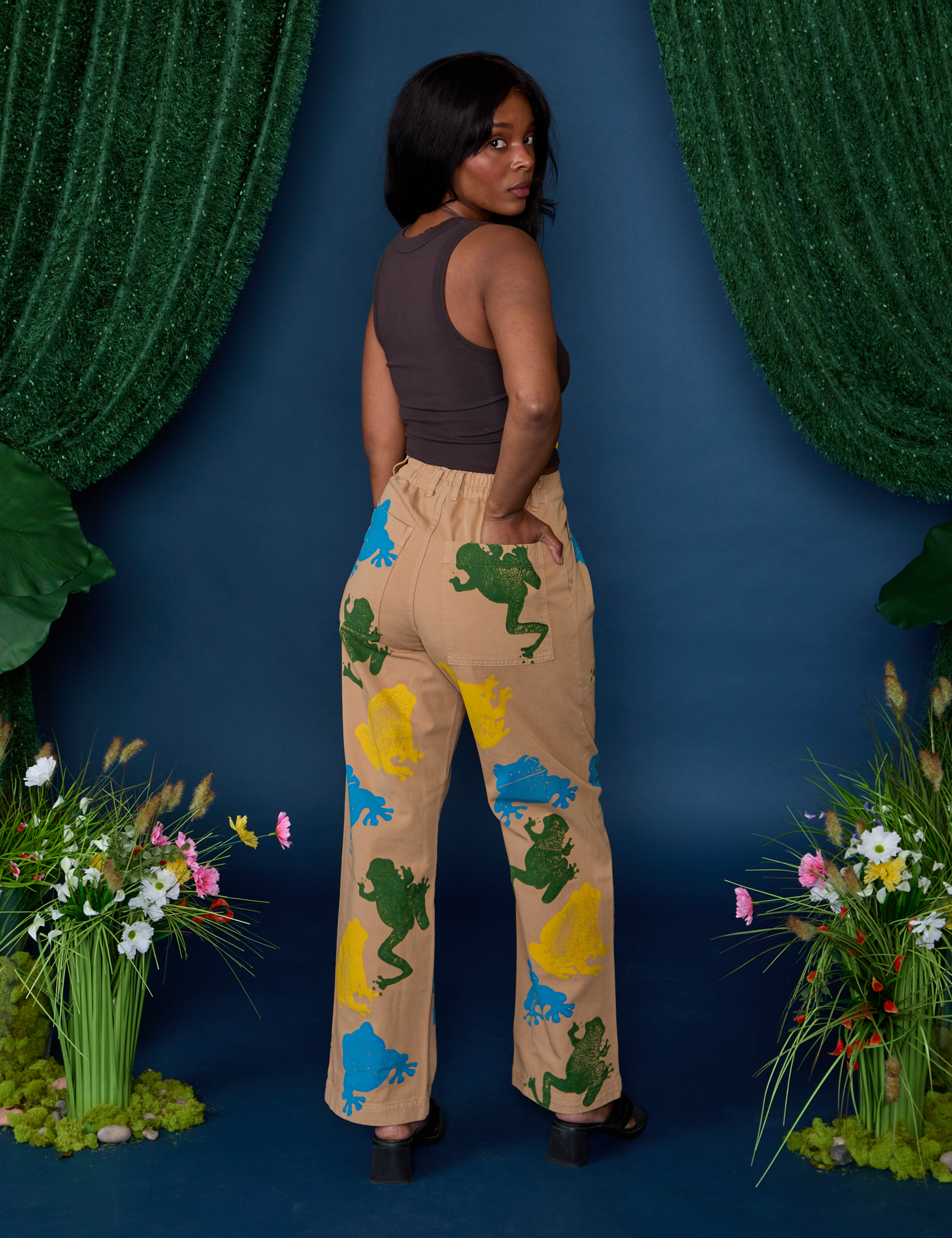 Angled back view of Paintstamped Work Pants in Froggy and espresso brown Cropped Tank on Kandia