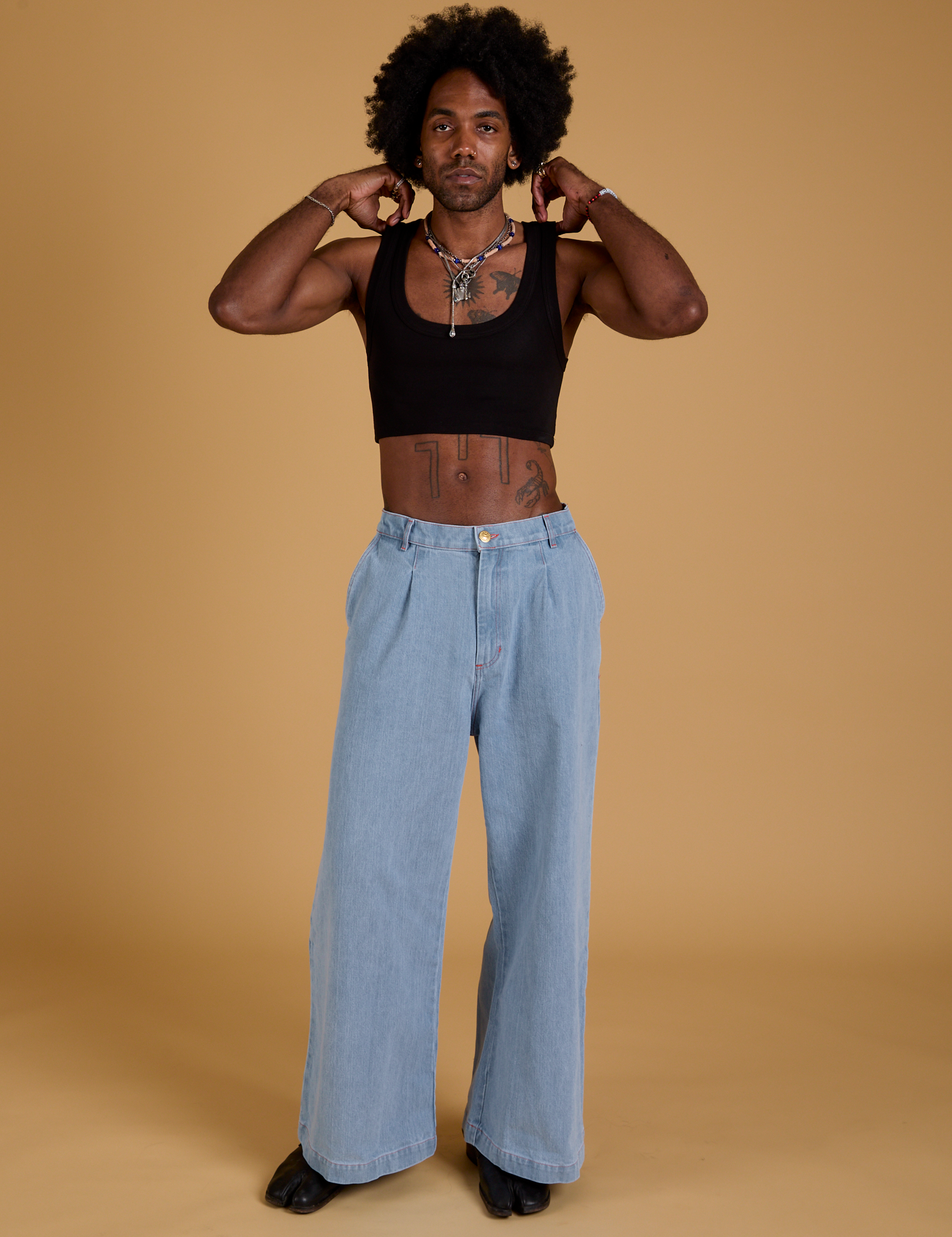 Jerrod is wearing Mini Tank in Basic Black and light wash Indigo Wide Leg Trousers