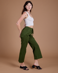 Side view of Organic Action Pants in Evergreen and vintage tee white Cropped Tank on Alex