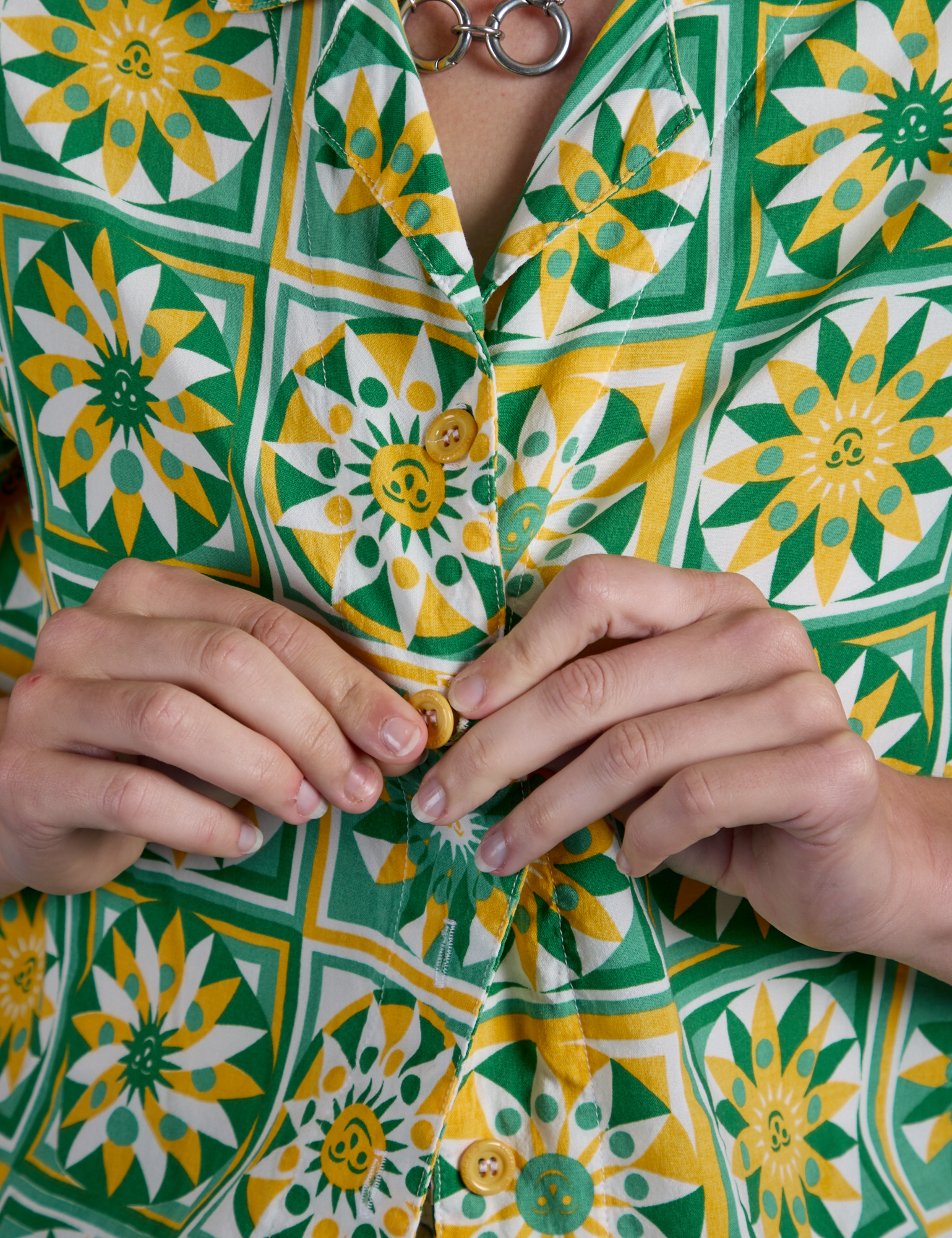 Close up of Alex buttoning up the Spring Quilt Print Pantry Button-Up