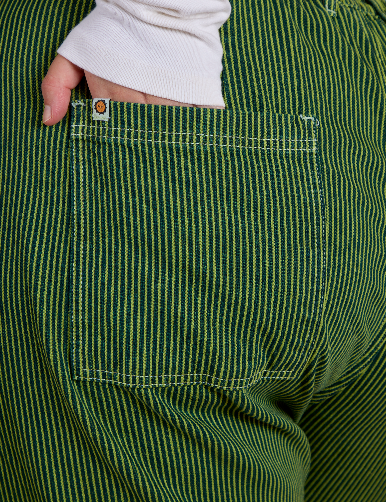 Close up of Juliet's hand in the back pocket of Railroad Denim Work Pants in Gross Green Overdye