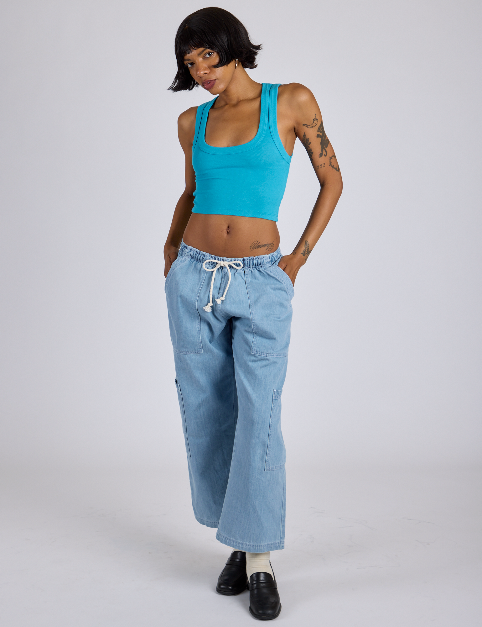 Kira is wearing Cropped Tank Top in Hawaiian Blue and light wash Denim Drop Pocket Pants