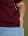 Close up of Juliet holding the bottom hem of Vintage Ringer Tee in Red Wine
