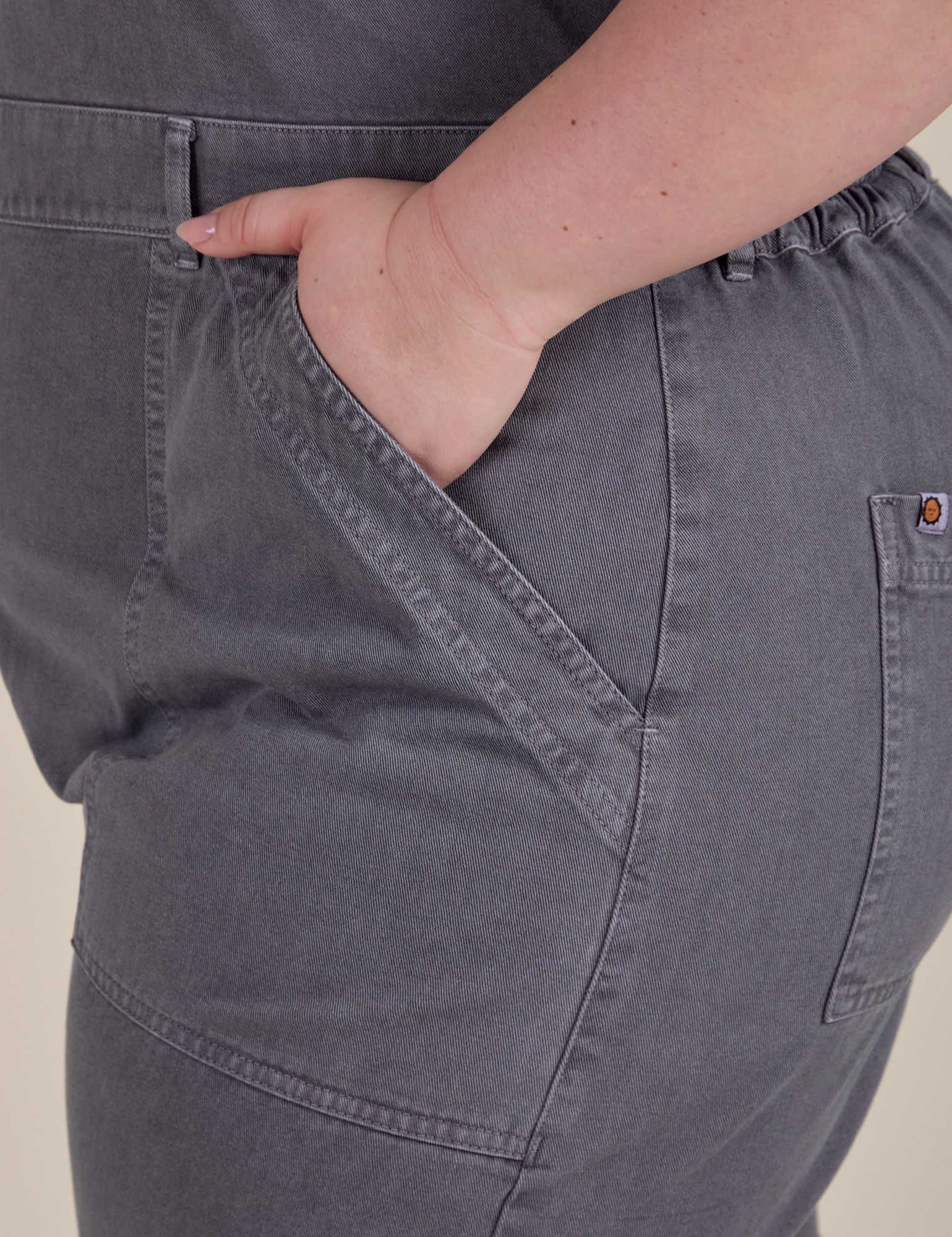 Close up of Ashley's hand in the front pocket of Short Sleeve Jumpsuit in Washed Grey