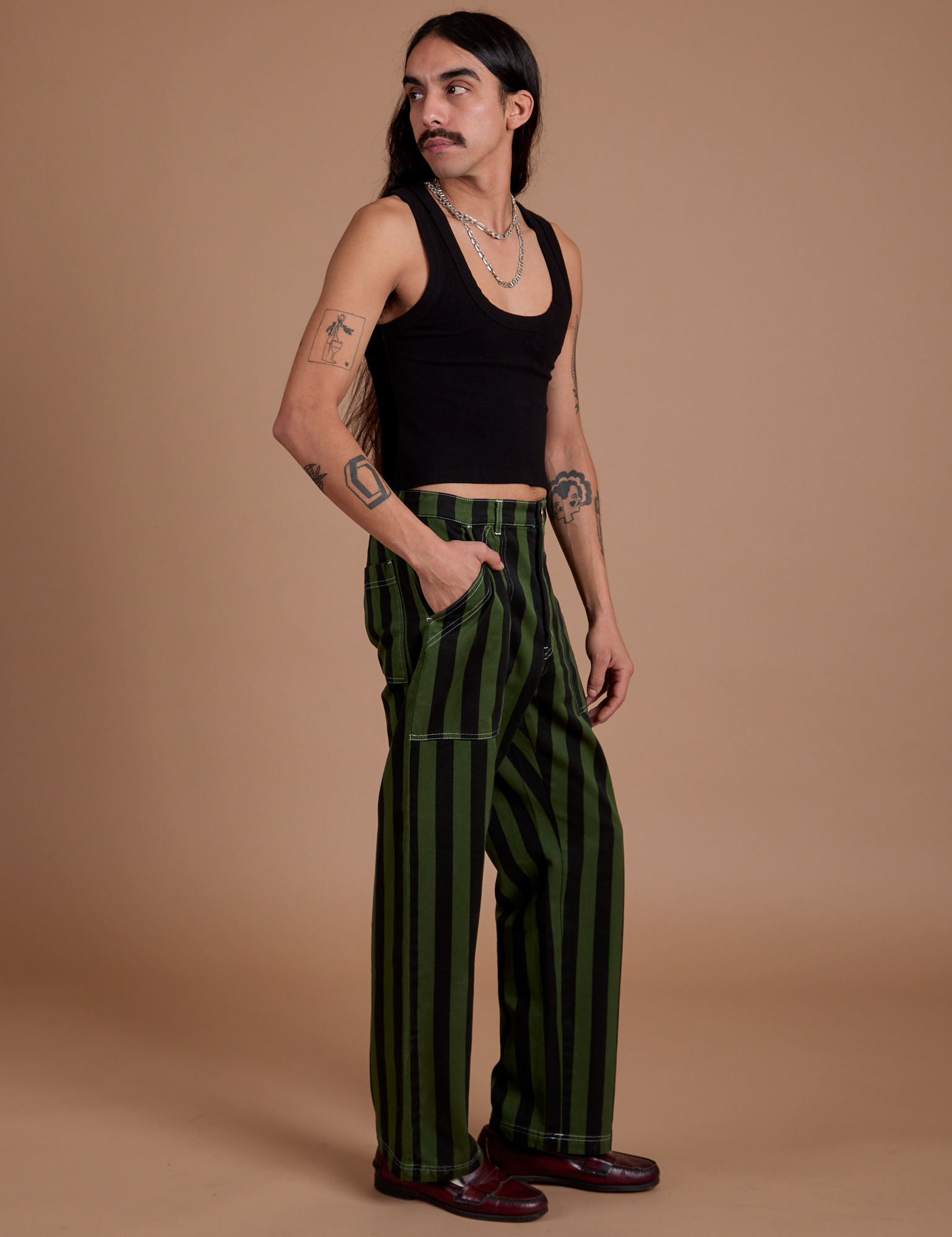 Side view of Black Stripe Work Pants in Evergreen and black Cropped Tank
