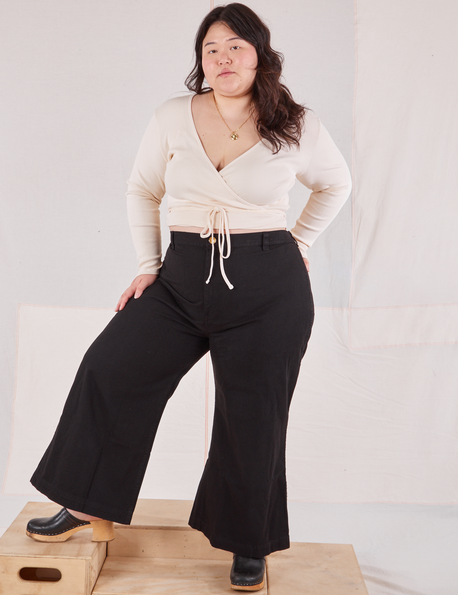 Ashley is wearing Wrap Top in Vintage Tee Off-White and black Bell Bottoms
