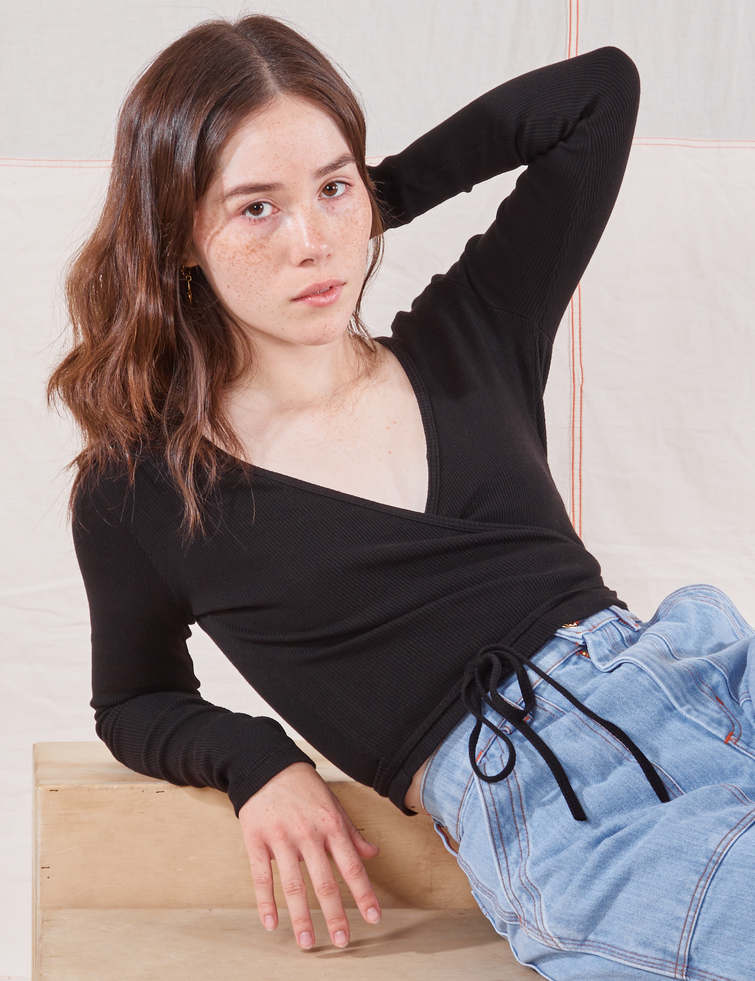 Hana is wearing Wrap Top in Basic Black