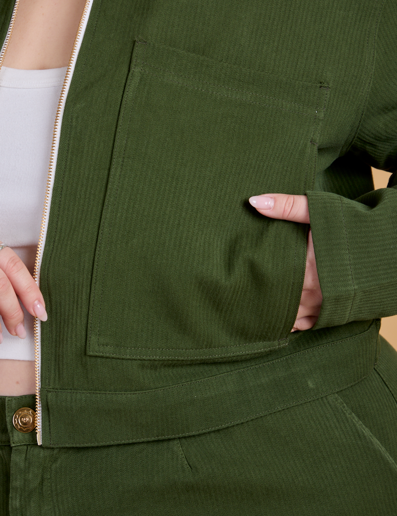Close up of Ashley's hand in the front pocket of Heritage Mechanic Jacket in Evergreen