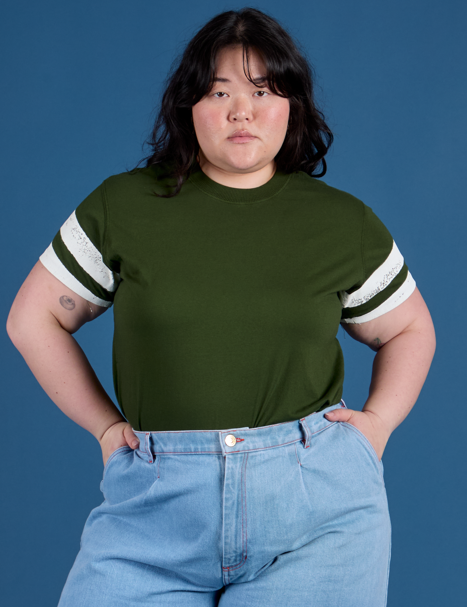 Ashley is wearing  Painted Vintage Tee in Evergreen tucked into light wash Wide Leg Trousers