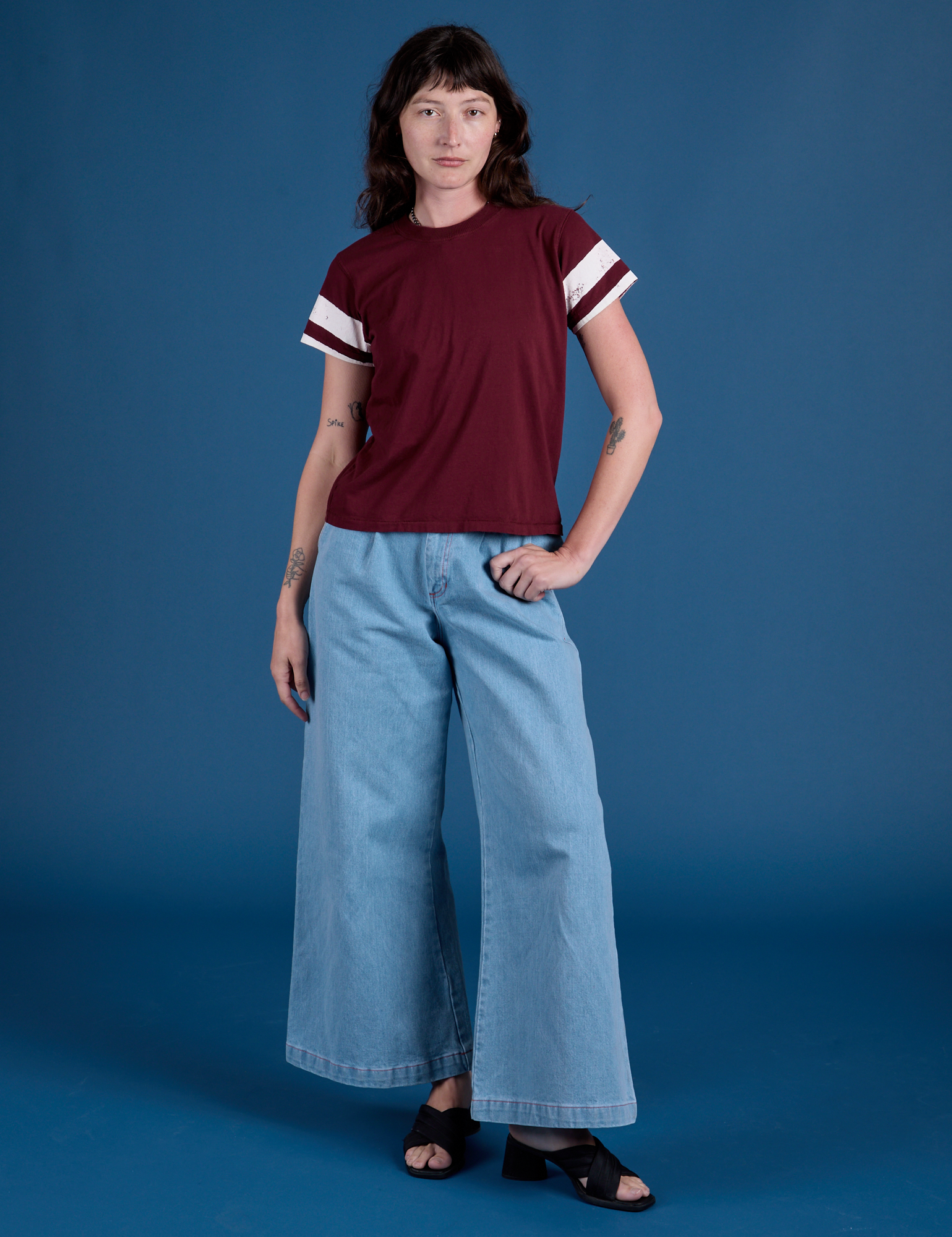 Alex is wearing Painted Vintage Tee in Red Wine and light wash Wide Leg Trousers