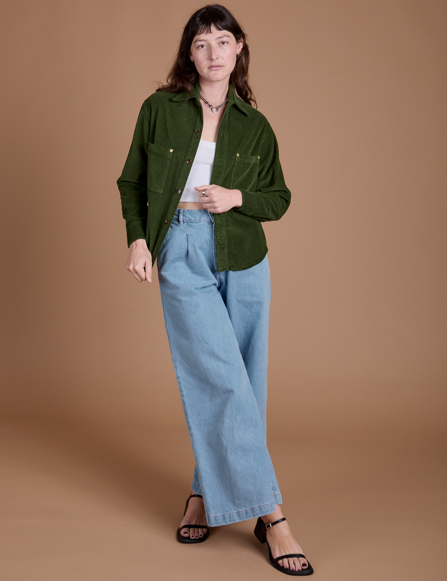 Alex is wearing Cropped Corduroy Overshirt in Evergreen and light wash Indigo Wide Leg Trousers