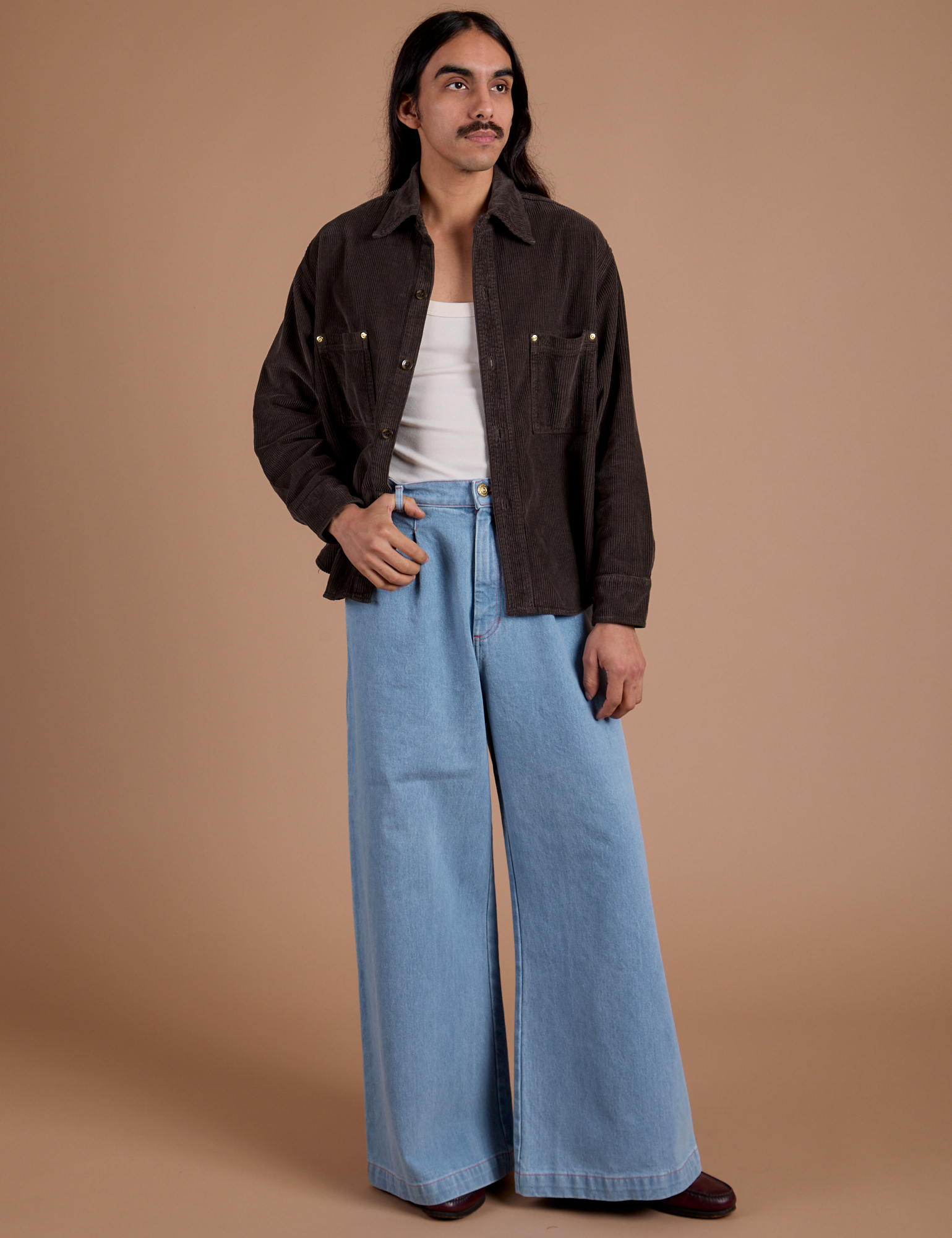 Anthony is wearing Cropped Corduroy Overshirt in Espresso Brown and light wash Indigo Wide Leg Trousers