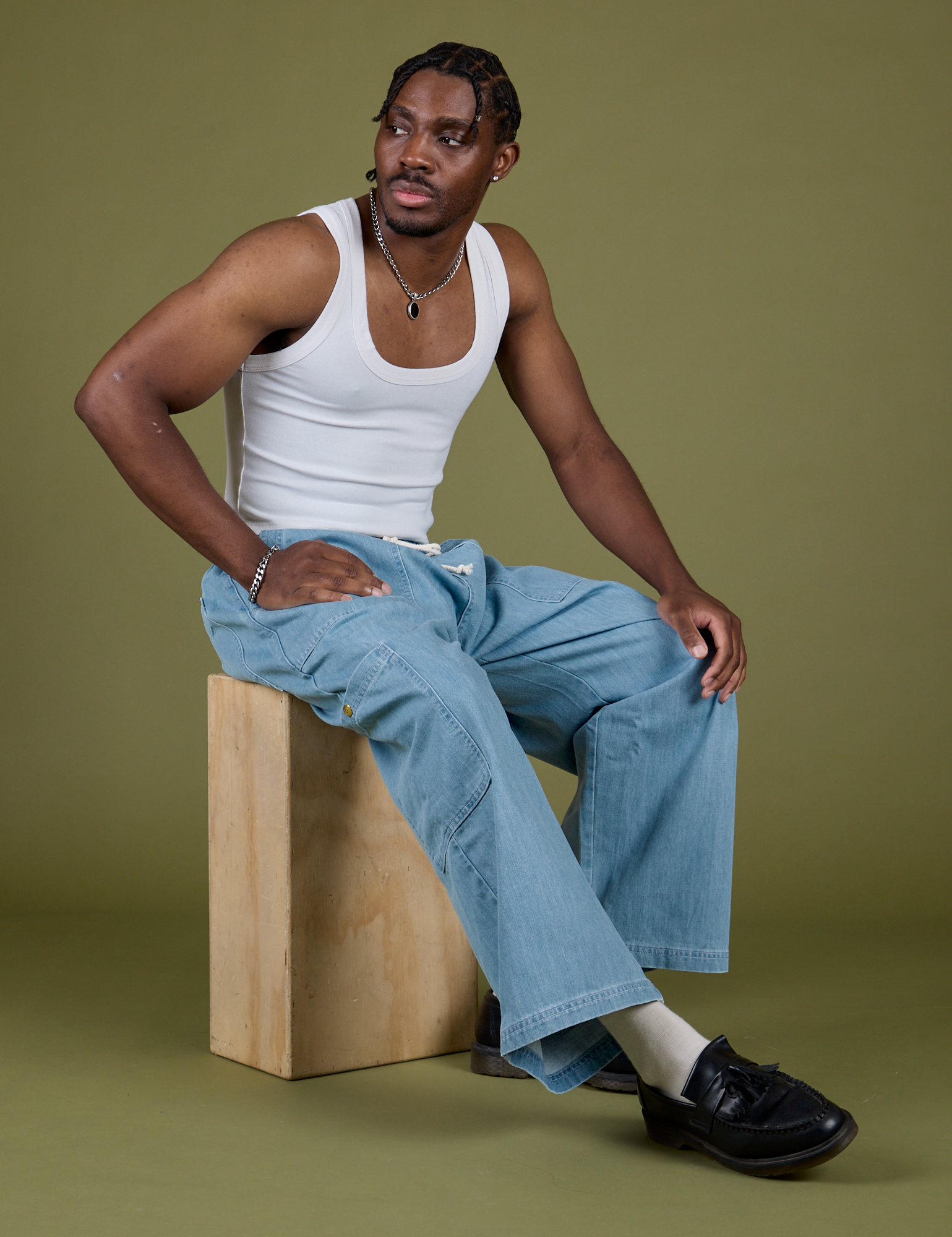 Isaac is wearing Denim Drop Pocket Pants in Light Wash and Cropped Tank in Vintage Tee White