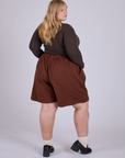 Pleated Trouser Shorts in Fudgesicle Brown angled back view on Juliet