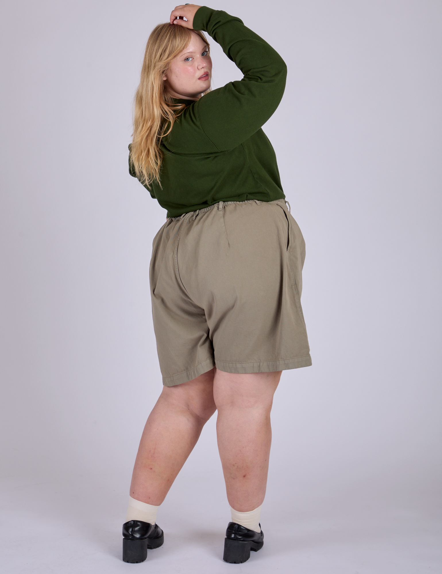 Angled back view of Pleated Trouser Shorts in Khaki Grey and evergreen Long Sleeve Burly Tee