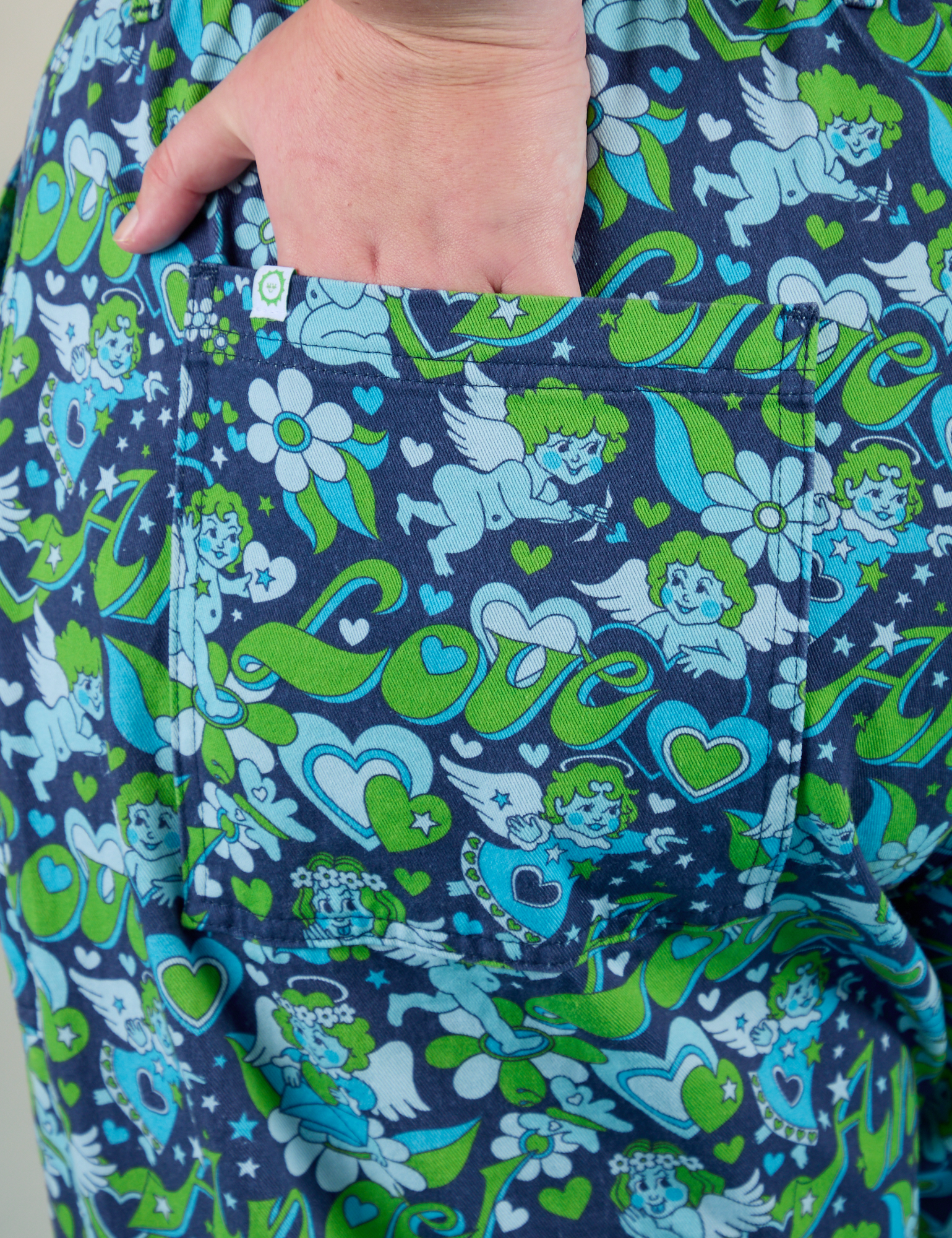 Close up of Juliet's hand in the back pocket of Angel Print Jumpsuit