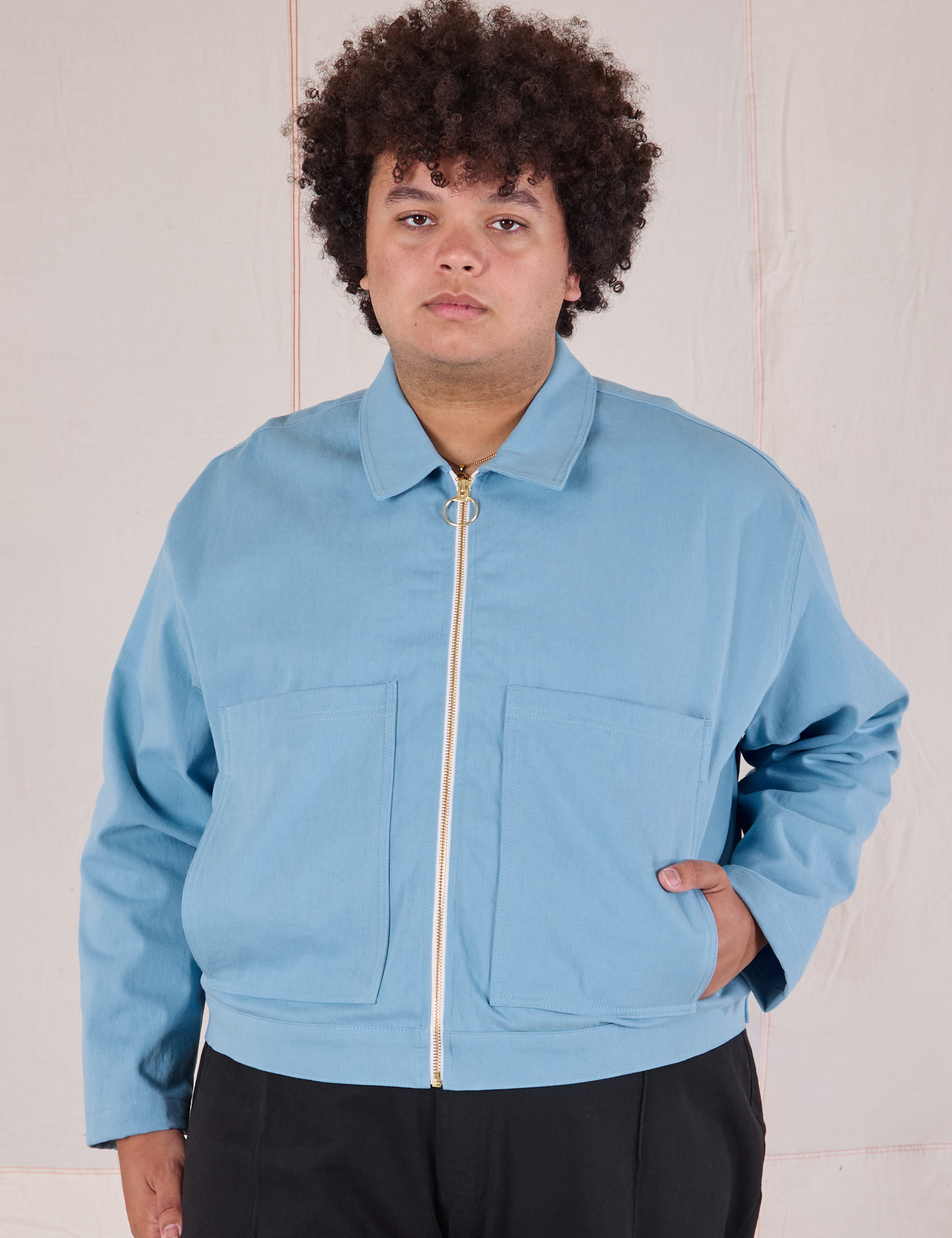 Miguel is wearing a zipped up Mechanic Jacket in Baby Blue