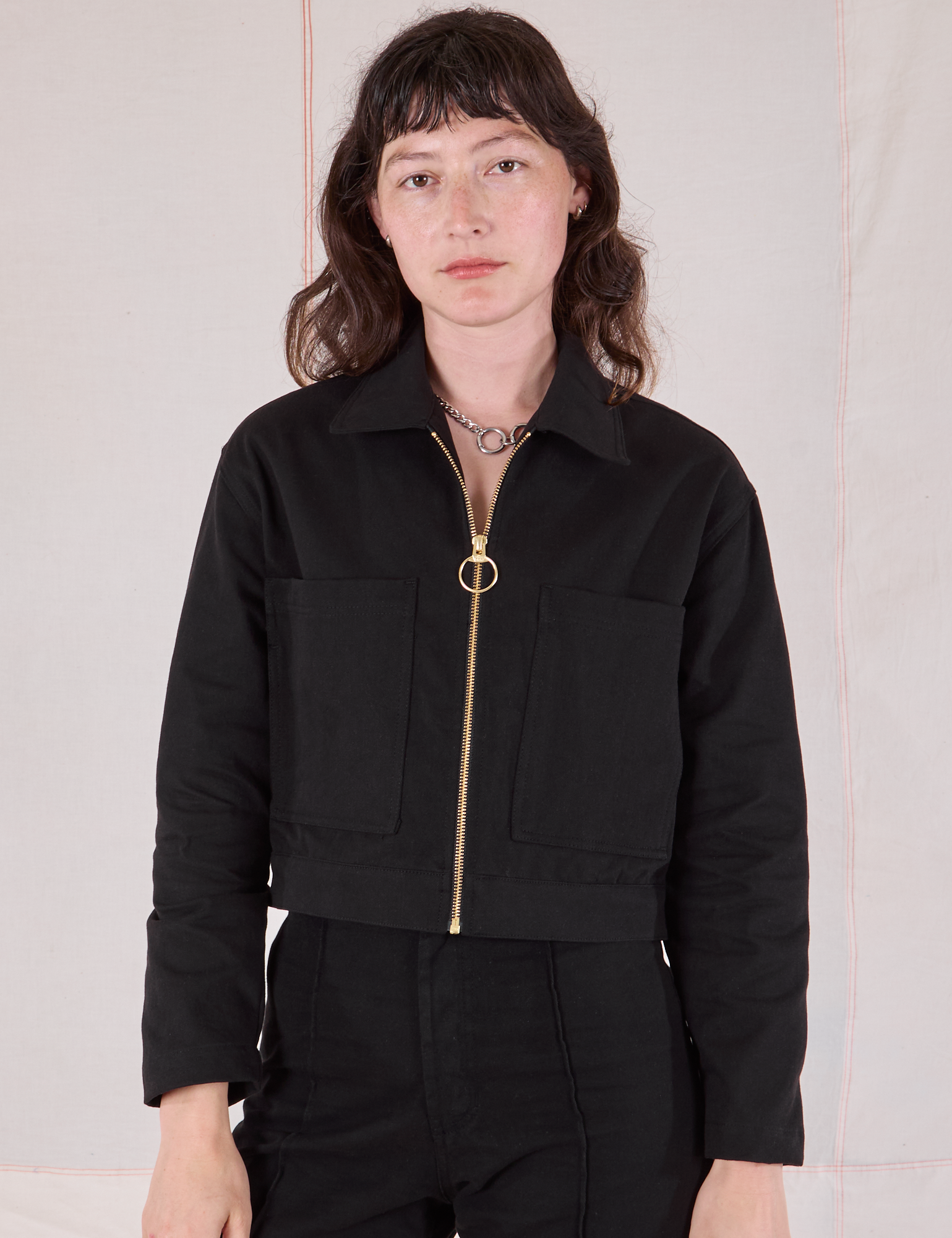 Alex is wearing a zipped up Mechanic Jacket in Basic Black
