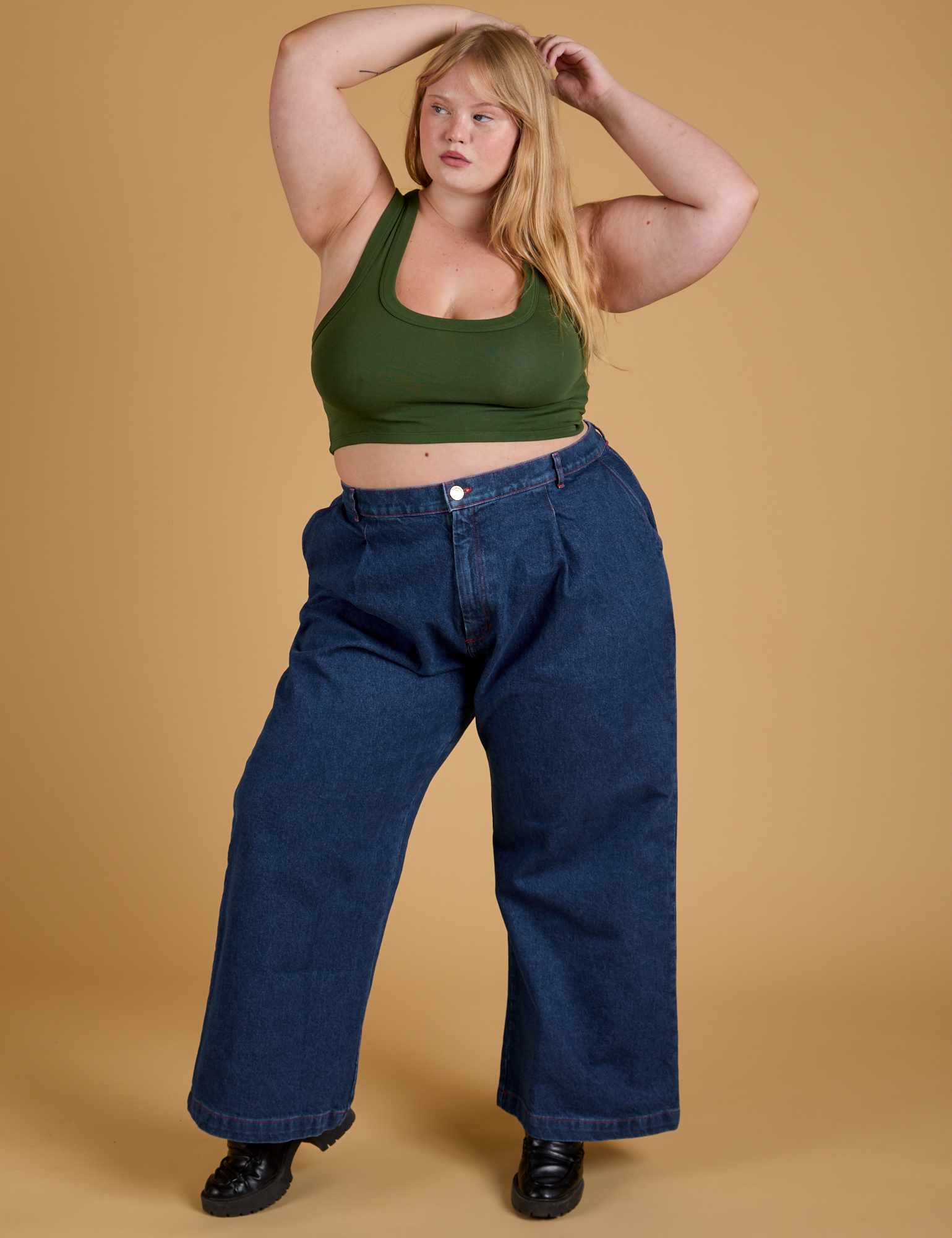 Juliet is wearing Mini Tank in Evergreen and dark wash Indigo Wide Leg Trousers