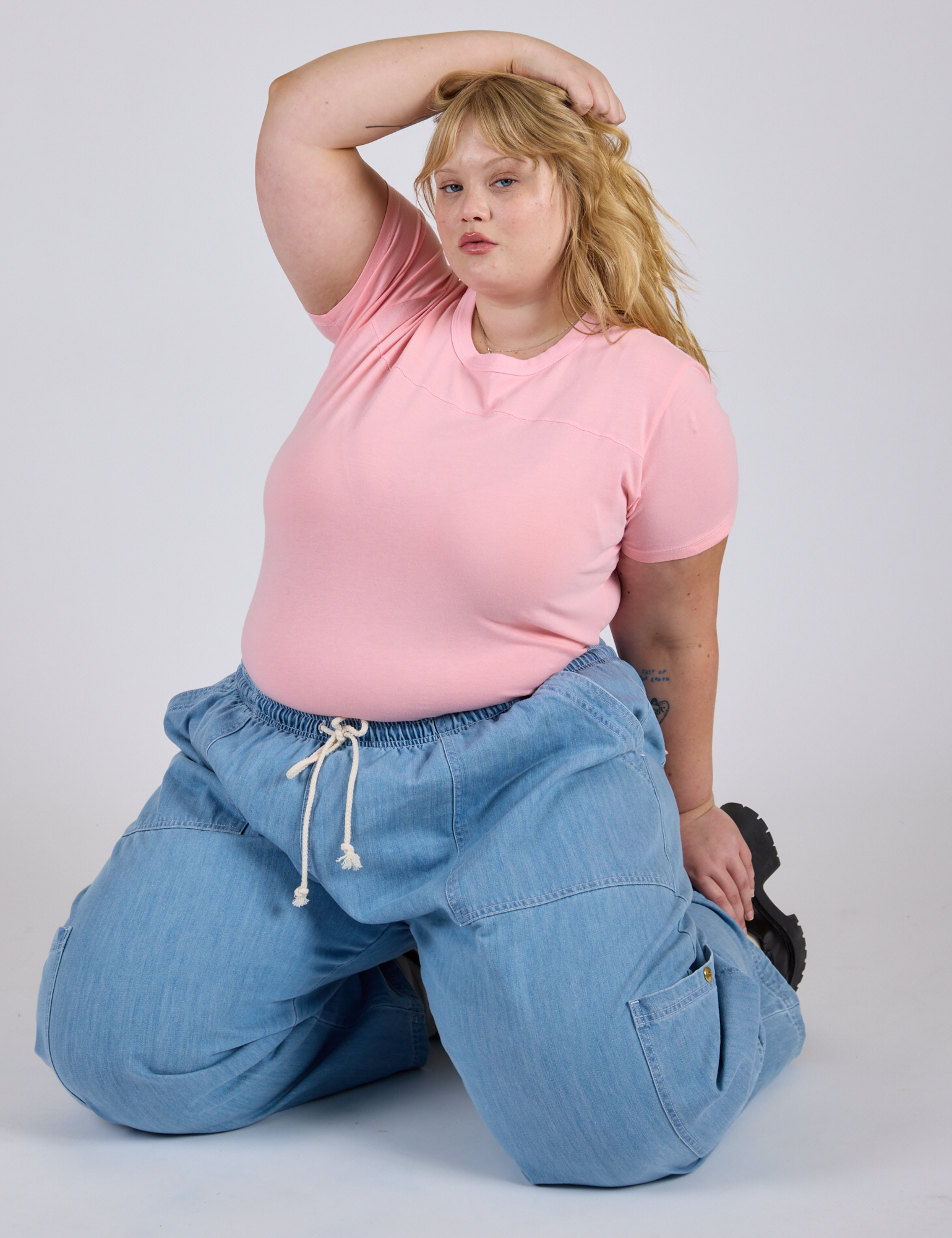 Juliet is wearing Jr. Varsity Tee in Baby Pink and light wash Denim Drop Pocket Pants