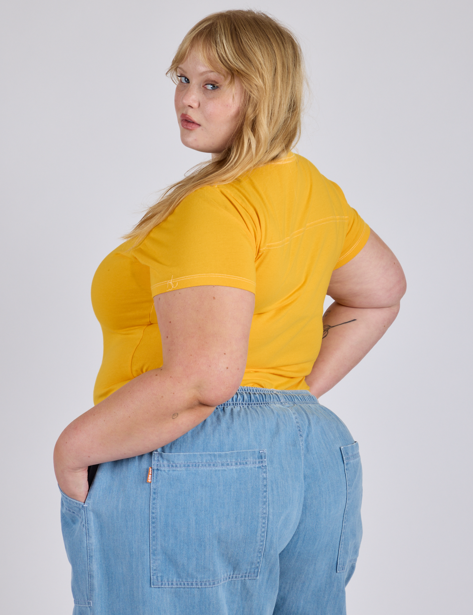 Angled back view of Jr. Varsity Tee in Sunshine Yellow on Juliet