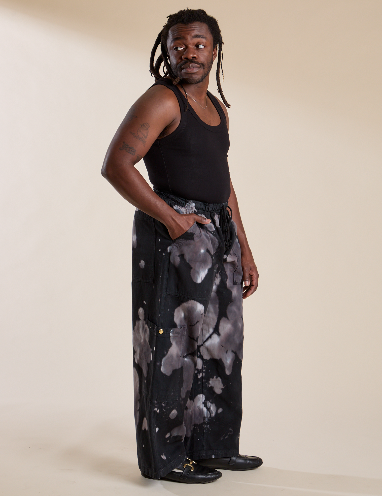 Side view of Magic Waters Drop Pocket Pants in Ink Blot and black Cropped Tank on Demi