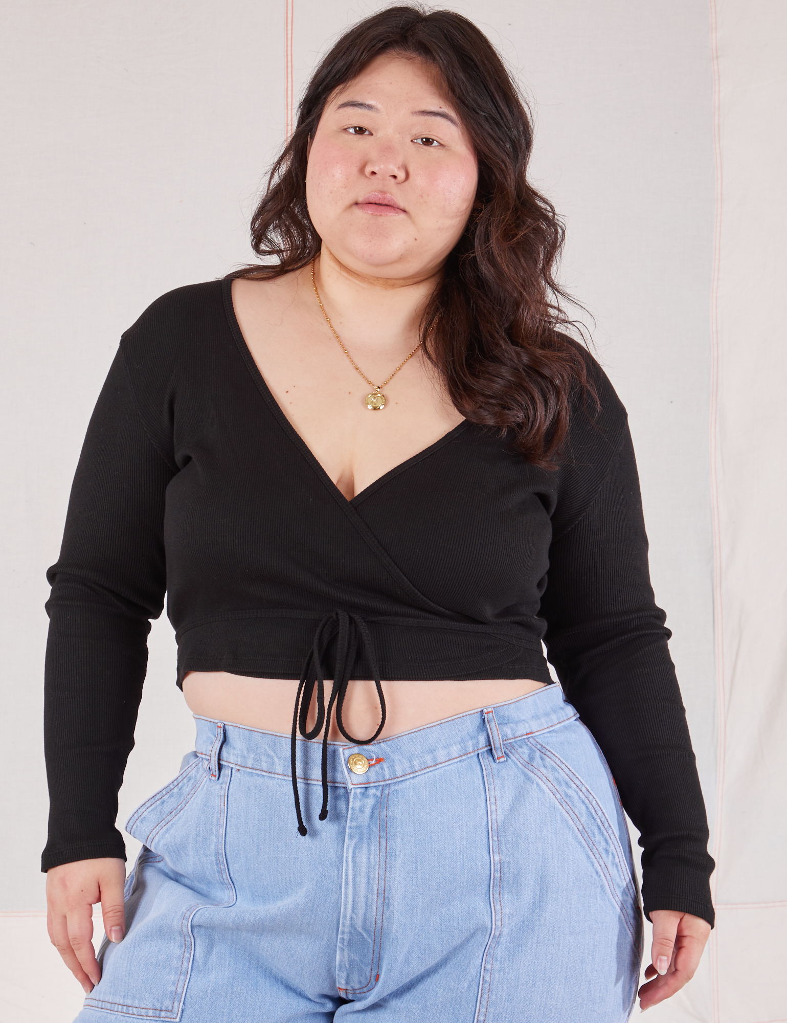 Ashley is 5'7" and wearing size 4 Wrap Top in Basic Black