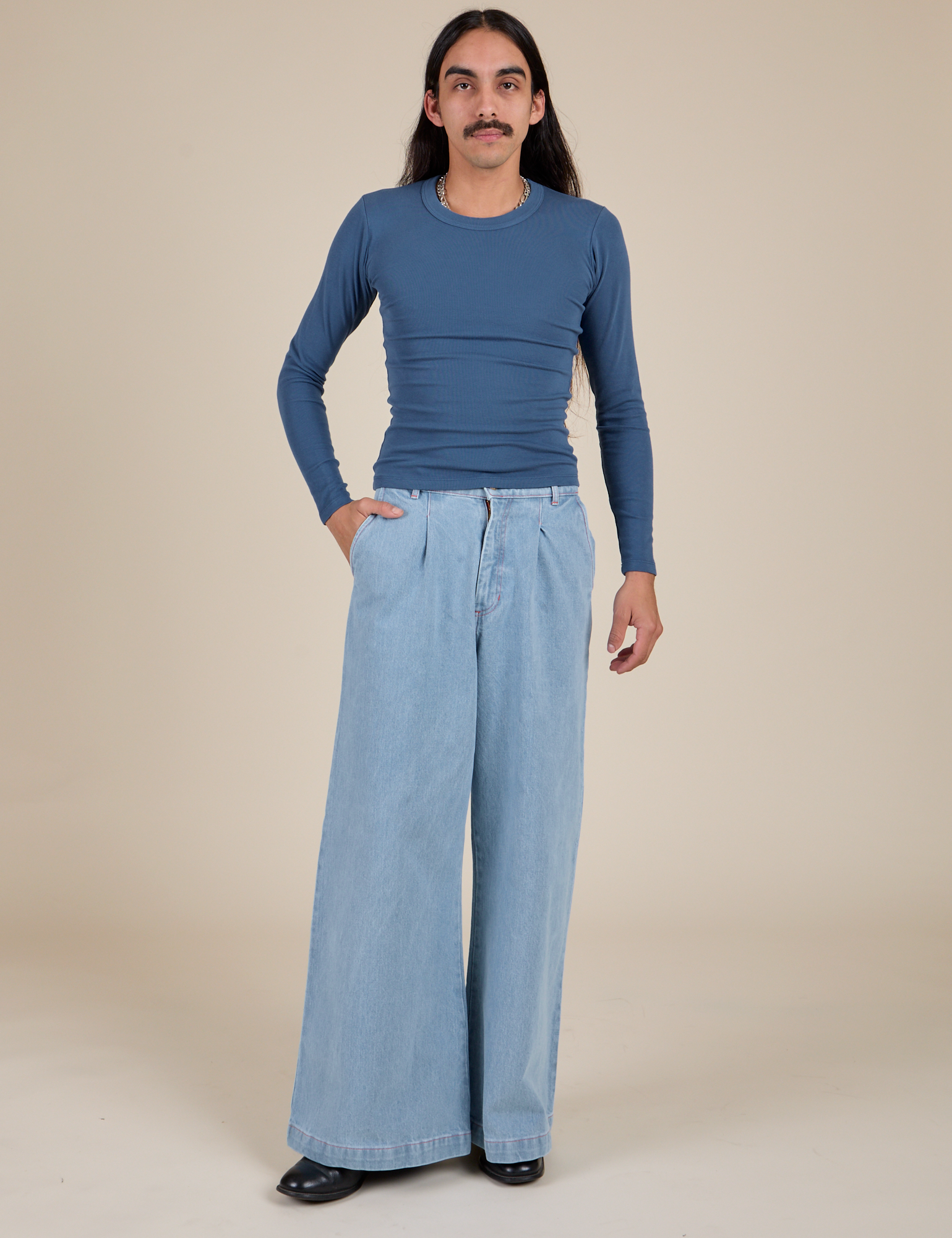 Anthony is wearing Long Sleeve Baby Tee in French Blue and light wash Indigo Wide Leg Trousers