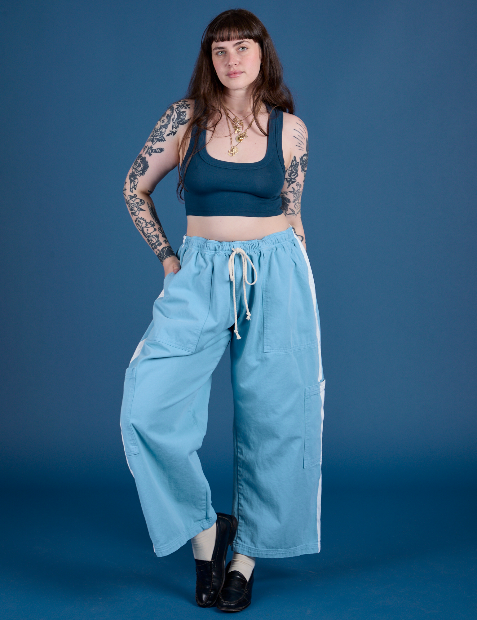 Sydney is 5’9” and wearing L Painted Drop Pocket Cargo Pants in Baby Blue paired with lagoon Mini Tank