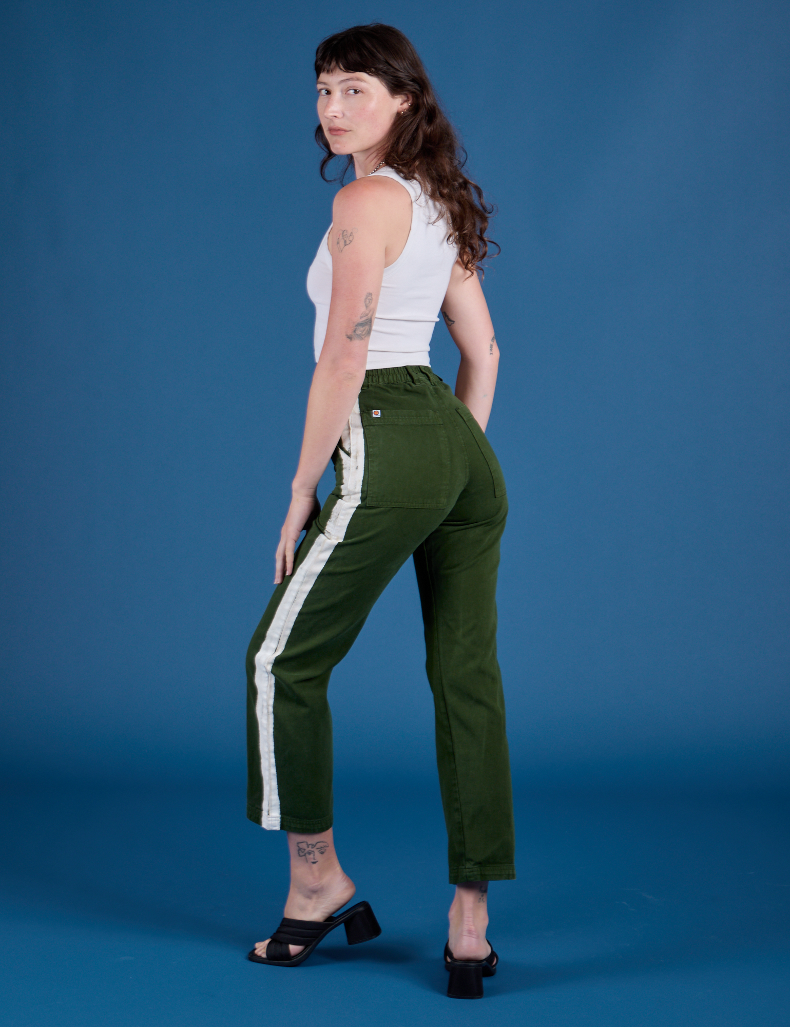 Angled front view of Painted Work Pants in Evergreen and vintage tee white Cropped Tank on Alex