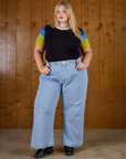 Juliet is wearing Calypso Tee in Black Multi tucked into light wash denim wide leg trousers