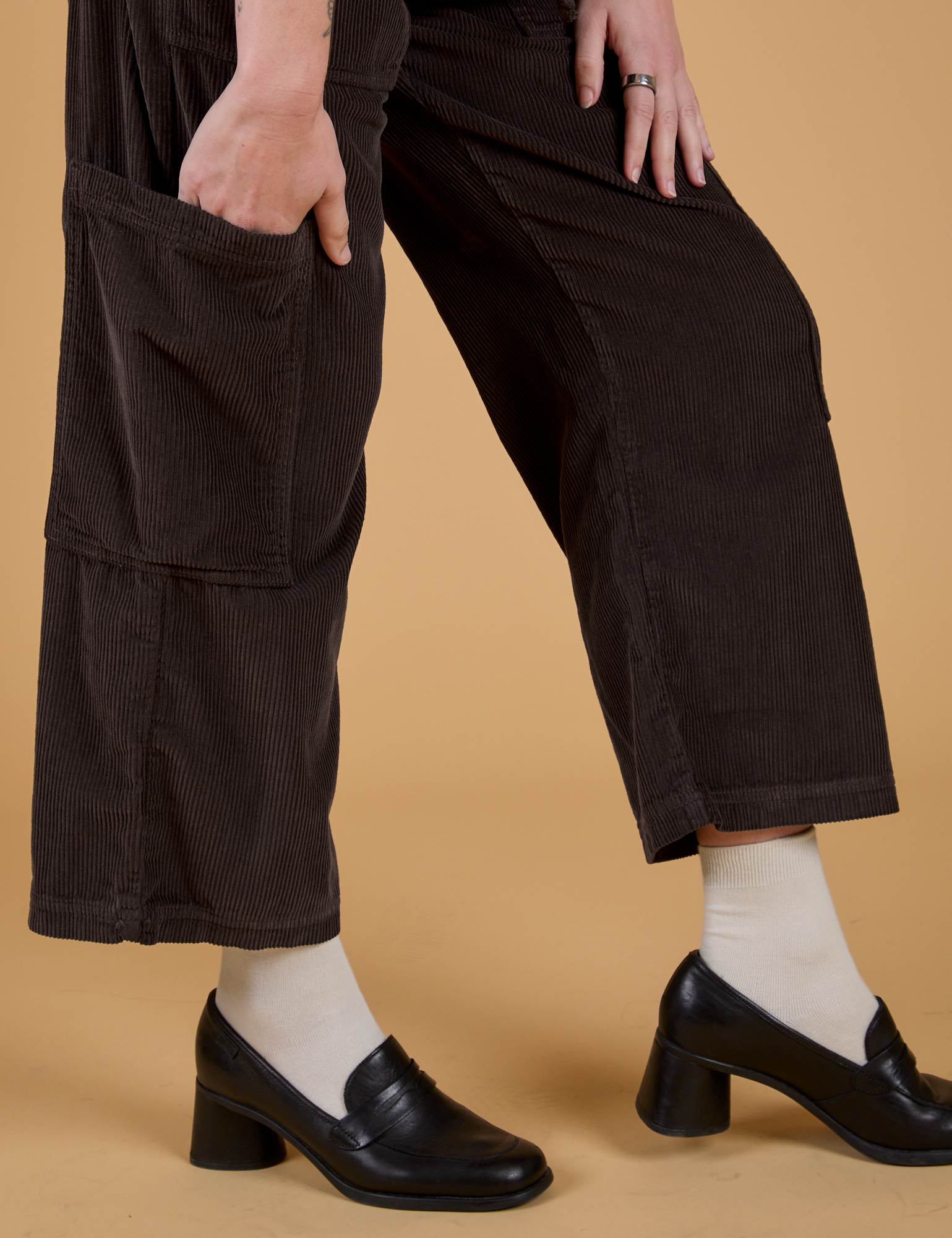 Pant leg side view close up of Corduroy Drop Pocket Cargo Pants in Espresso Brown with Alex's hand in the side pocket