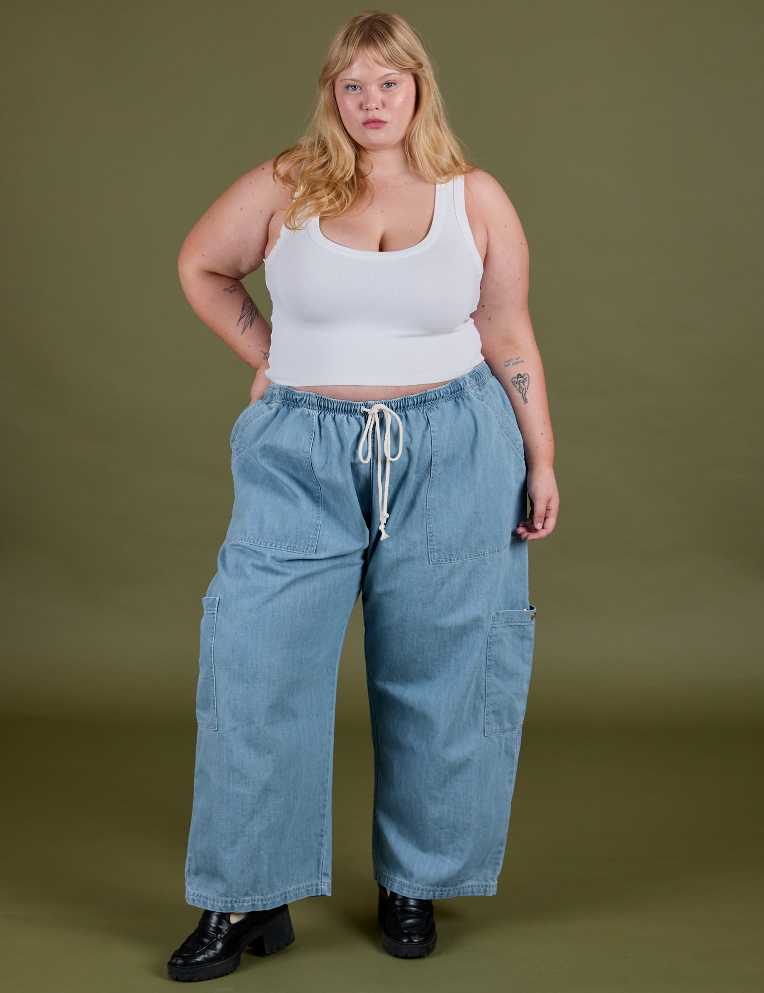 Juliet is 5’7” and wearing 2XL Denim Drop Pocket Pants in Light Wash paired with vintage tee white Cropped Tank