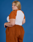 Angled back view of Produce Raglan Tee in Orange on Juliet