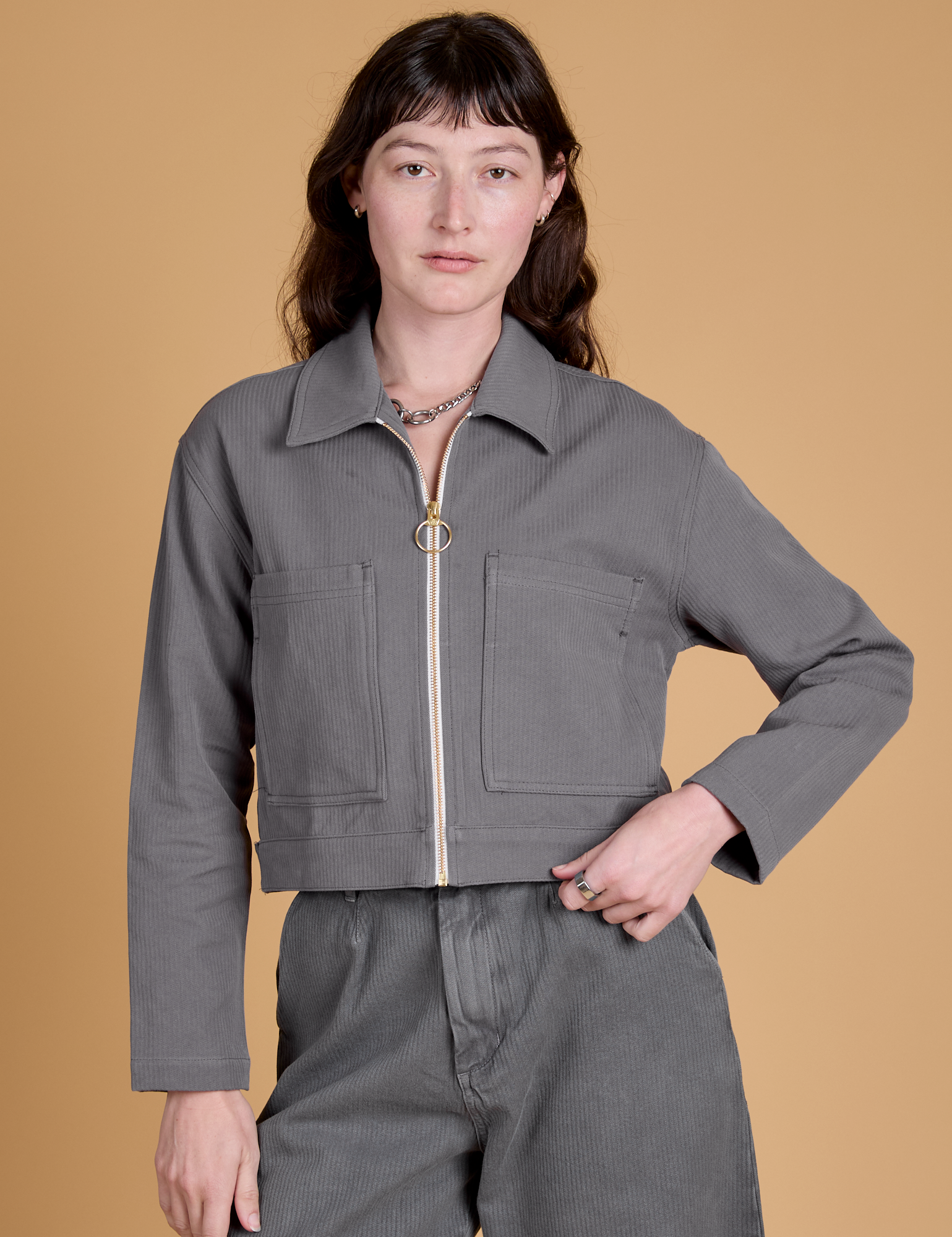 Alex is wearing a zipped up Heritage Mechanic Jacket in Washed Grey